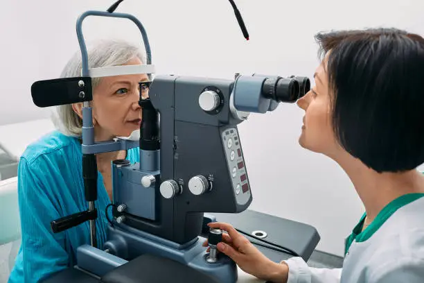 Optician looking into patients eyes